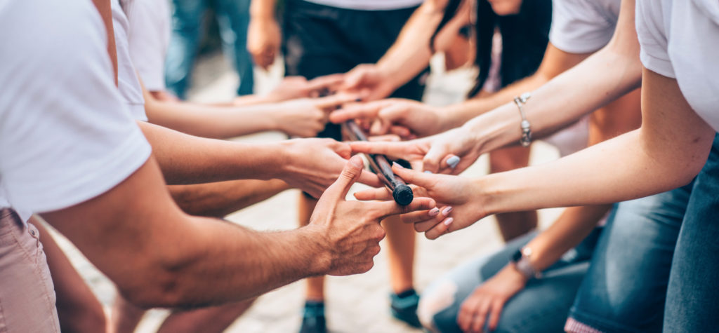 teambuilding exercises with stick and hands of colleagues