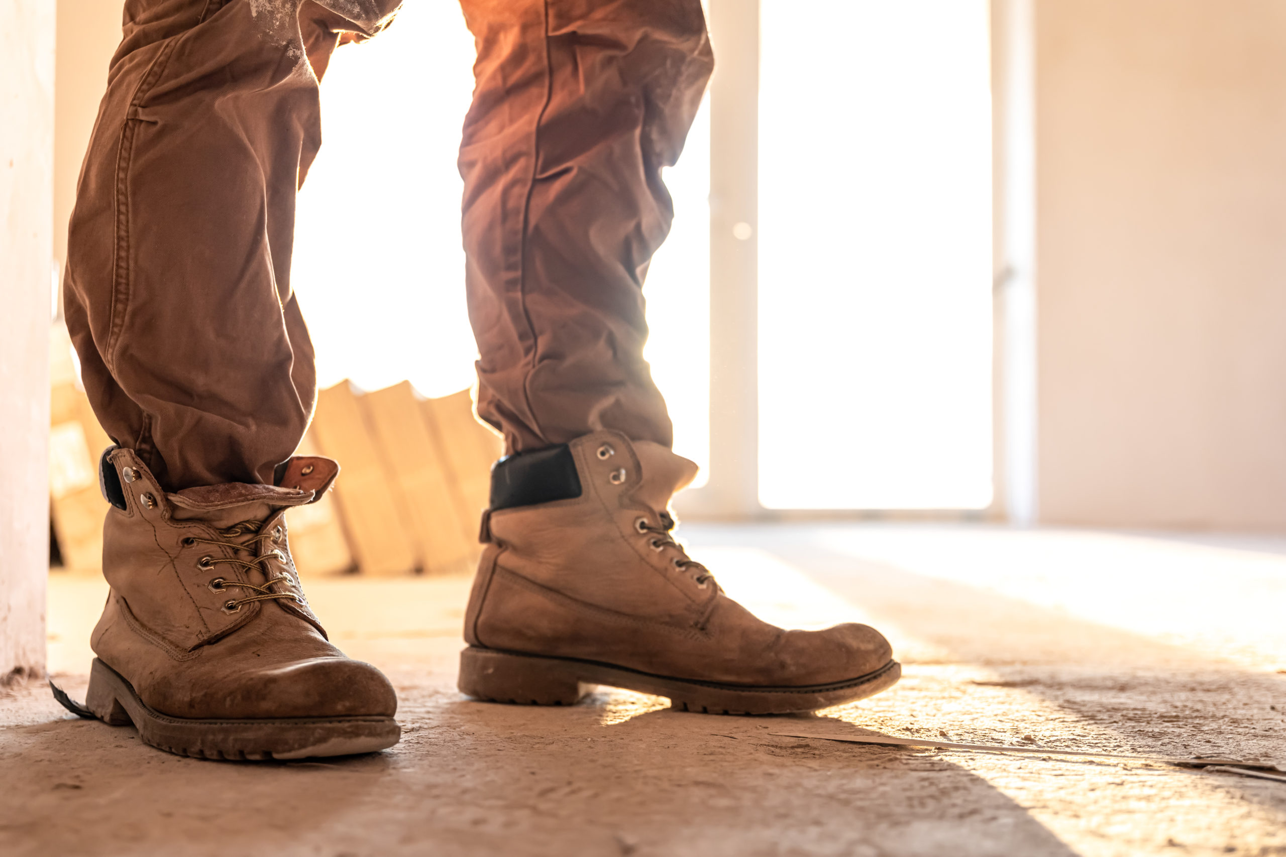 Close-up of work shoes of a builder at a construction site, copy space.